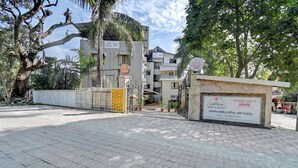 Ein verschlossenes Tor zu einem Gebäude, an dem ein Schild zu sehen ist, das angibt, dass es sich um das Hotel Kohinoor Exotica handelt.