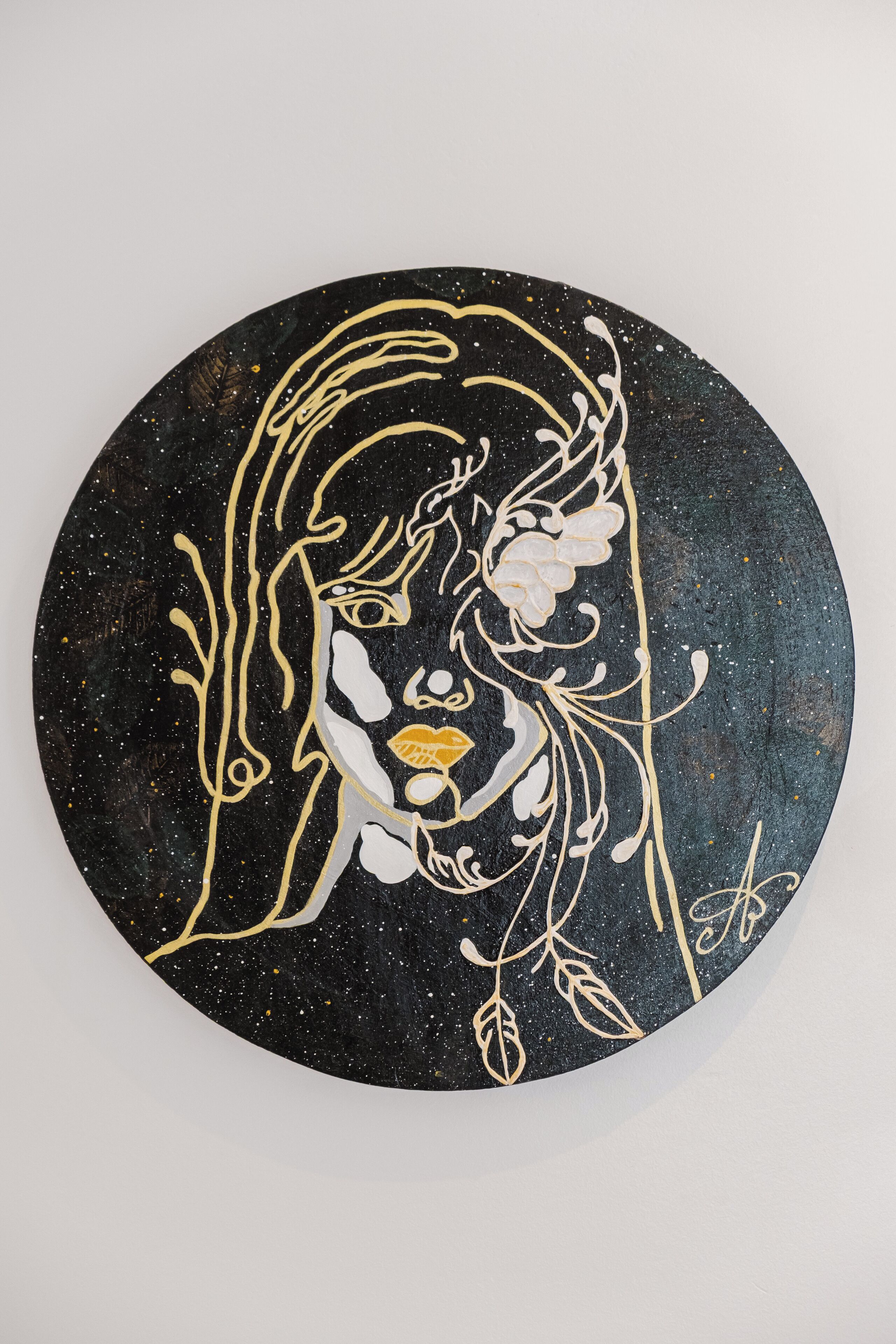 A circular artwork with a central figure surrounded by abstract designs.