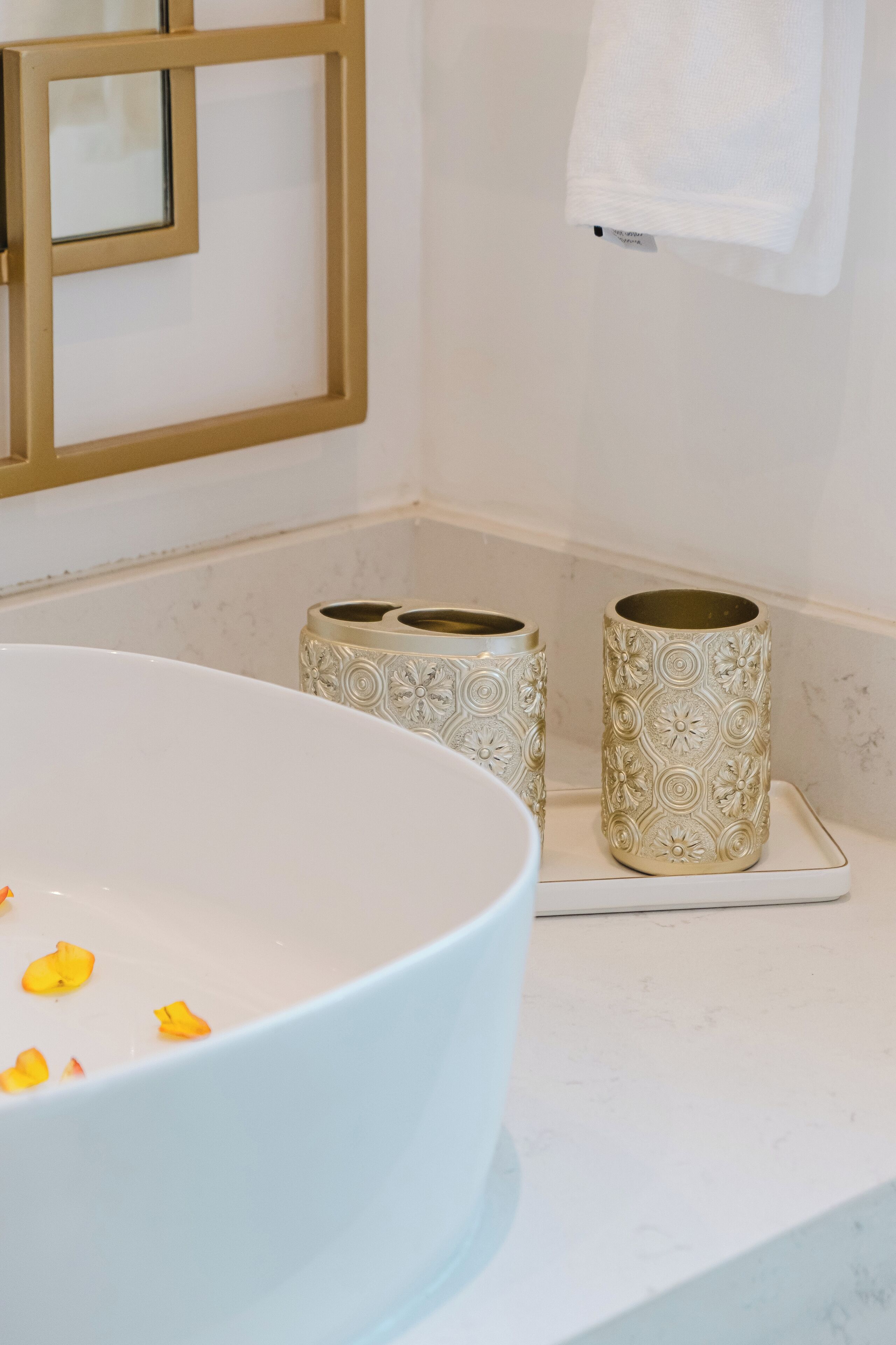 Une salle de bain avec un grand lavabo blanc, deux chandeliers décorés et une serviette blanche accrochée au mur.