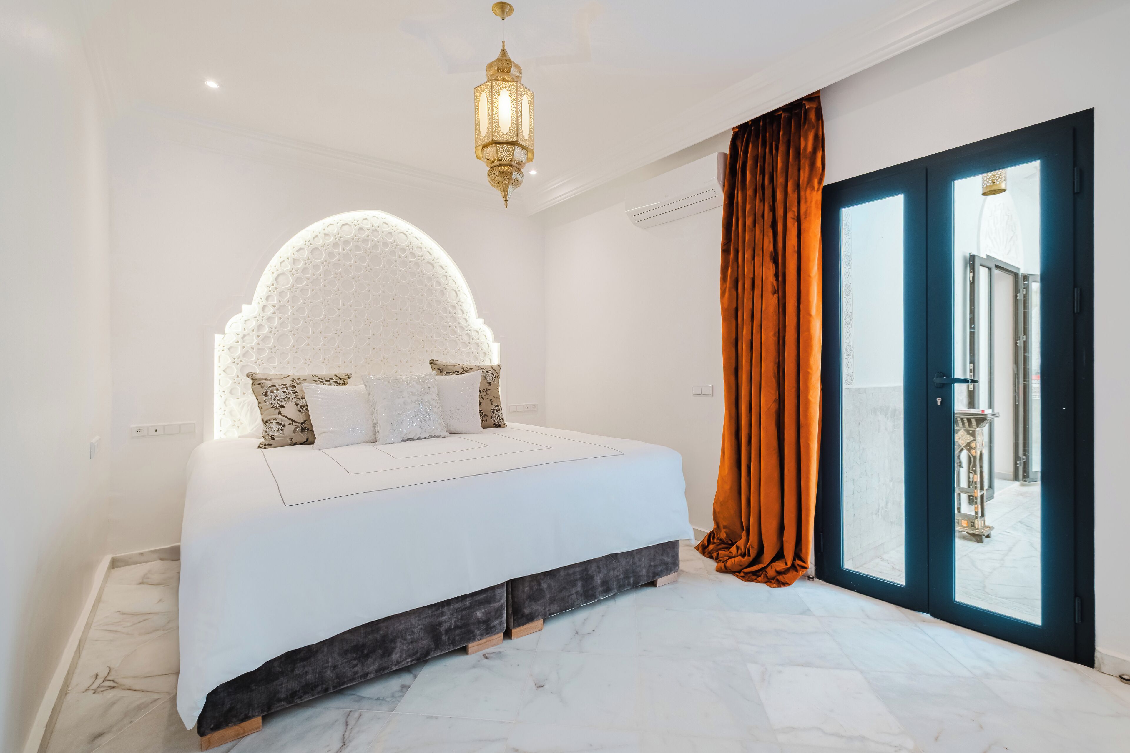 Un dormitorio moderno con una cama grande, una pared decorativa y vistas a través de un ventanal.