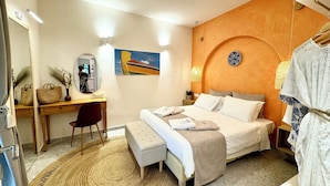 Une chambre à coucher comprenant un lit, une table de chevet, une chaise, un bureau et un miroir.