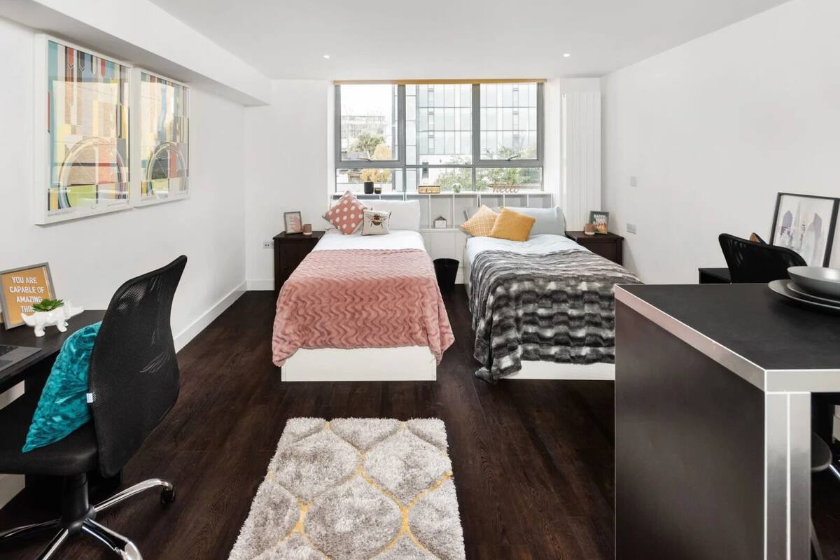 A modern bedroom with a large window, a desk, and a chair.
