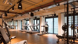 A gym with treadmills, elliptical machines, and weightlifting equipment. - Chapter Aldgate - Campus Accommodation (London)