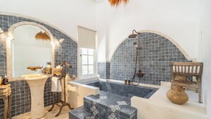 A bathroom with a freestanding bathtub, a large mirror, and a shower area. - La Santa Rosa (Jimbaran)