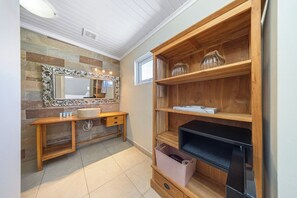 A bathroom with a wooden vanity, a large mirror, and built-in shelves. - Oranjestad Retreat: 4BR Paradise with Private Pool (Oranjestad)