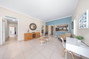 A spacious living area with a dining table, two chairs, a sofa, and a kitchen in the background. - Oranjestad Retreat: 4BR Paradise with Private Pool (Oranjestad)