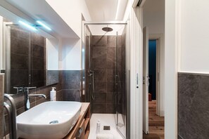 Appartement | Badkamer | Een douche, gratis toiletartikelen, een haardroger, handdoeken