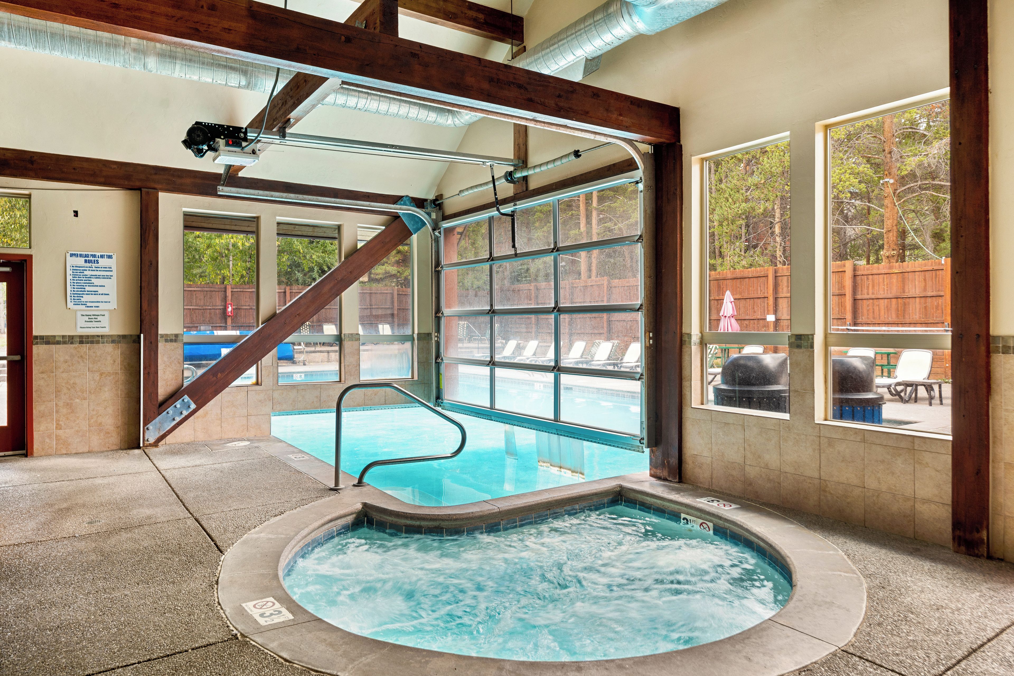 A hot tub area with a view of a pool and outdoor seating.