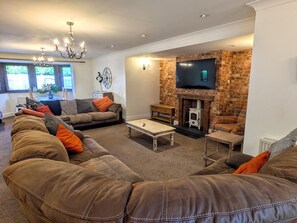 A living room with a fireplace, sofas, and a television. - Spacious home 4 large families, contractors welcome (Wolverhampton)