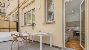 A small, modern apartment with a dining area, a kitchen, and a balcony. - Elegant Home with Terrace by Wonderful Italy (Turin)