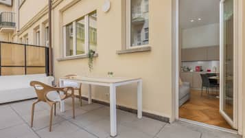 Un apartamento pequeño y moderno con comedor, cocina y balcón.