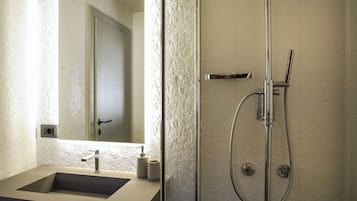Een moderne badkamer met een glazen douchecabine, een wastafel met spiegel en een structuurwand.