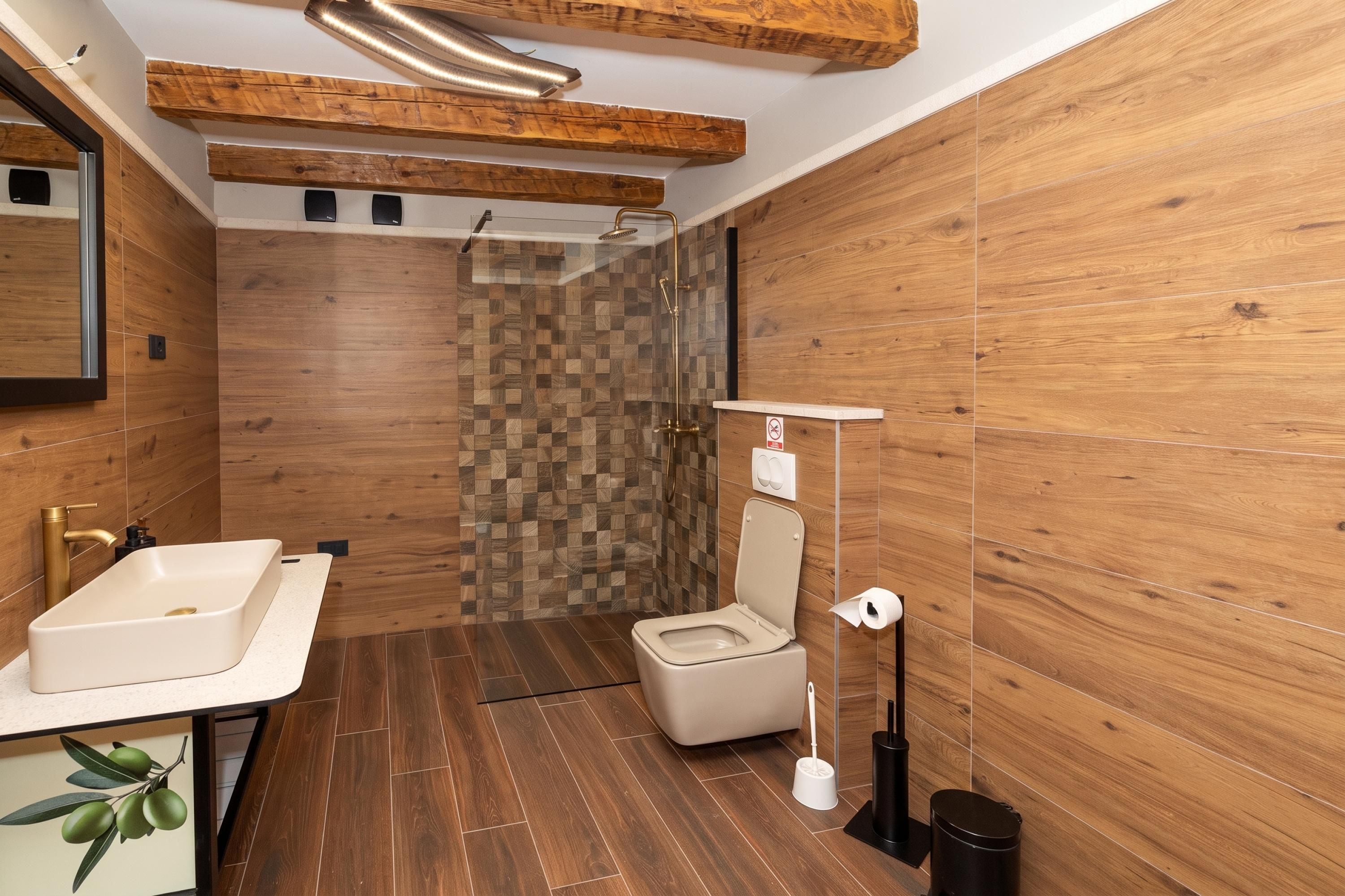 Une salle de bain moderne avec des murs en bois, une douche, des toilettes et un lavabo.