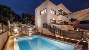 Un bâtiment moderne doté d  ’une piscine, d’un espace extérieur aménagé et d’un escalier.