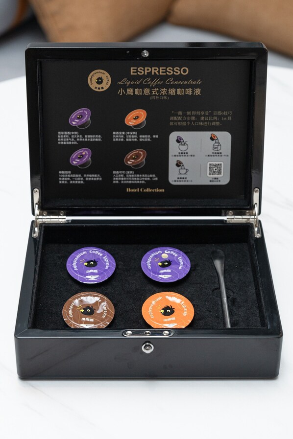 Una scatola nera contenente quattro capsule di caffè per hotel, etichettate 'ESPRESSO Liquid Coffee Concentrate'.