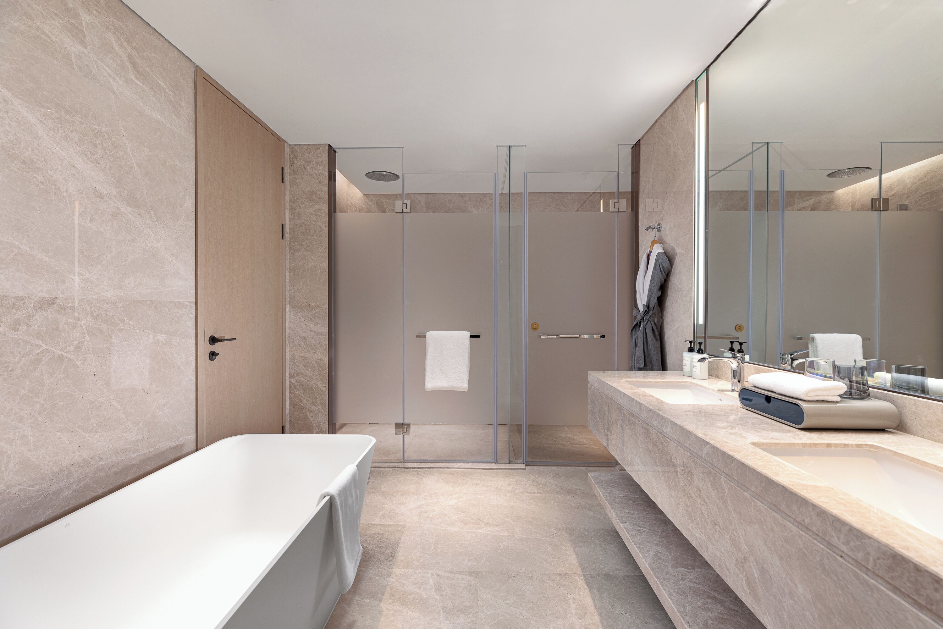 A modern bathroom with a large bathtub, a walk-in shower, and a vanity with a mirror.