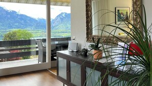 A modern room with a large window, a mirror, and a desk with a computer. - die Villa", Eine Wohnung für 6 Personen (Sigriswil)