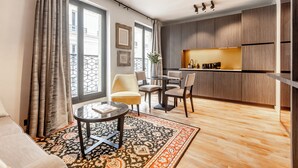 A modern apartment with a dining area, kitchen, and large windows. - Maison Barnes Paris Trocadero (Paris)