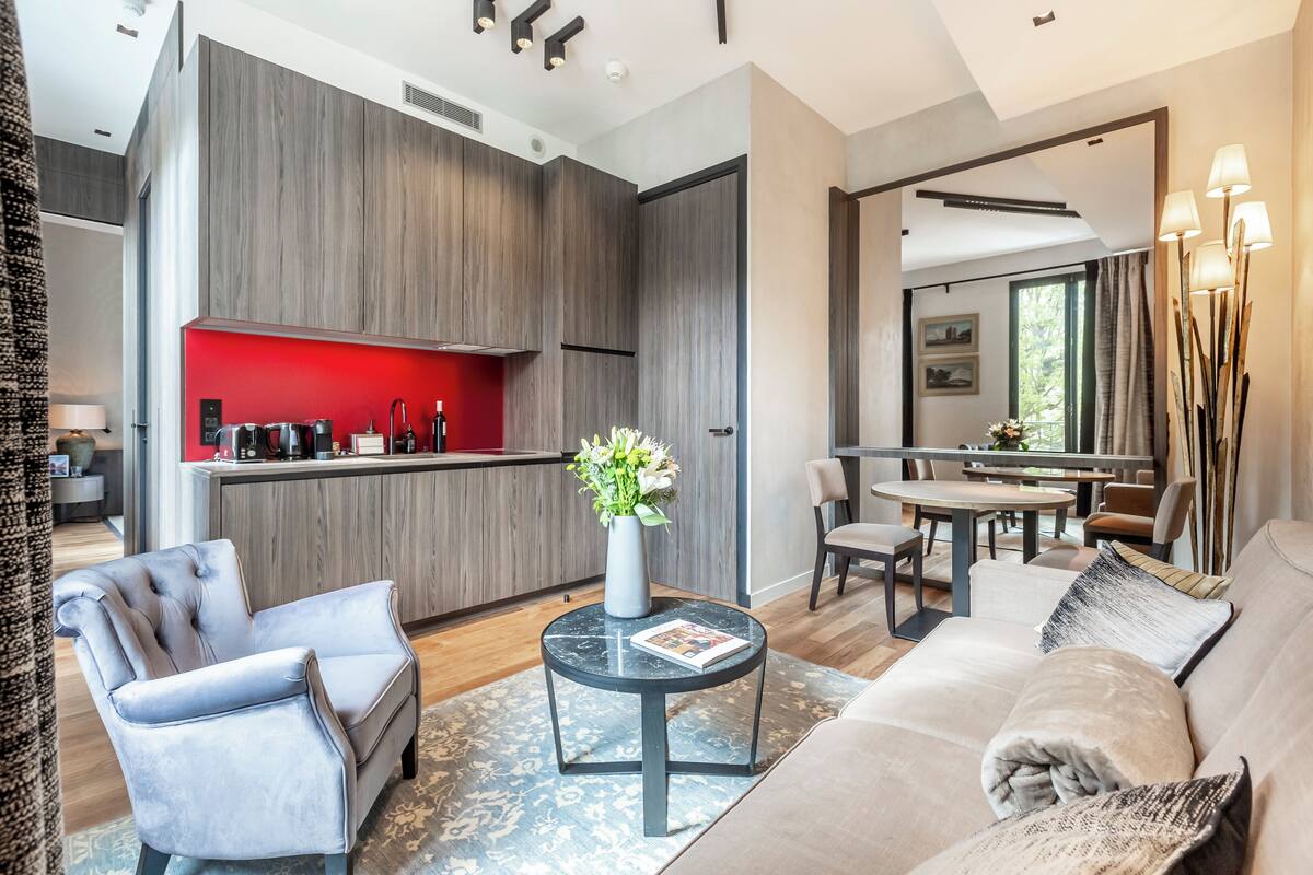 A modern living room with a sofa, armchair, and a round coffee table.