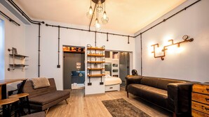 Un salon moderne comprenant un canapé, une table basse, une commode et une bibliothèque intégrée.
