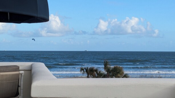 A beach view with a clear sky, ocean waves, and a distant ship. - Oceanfront 2br/2b, in Port Canaveral, Heated Pool & Spa, Ocean Views (Cape Canaveral)