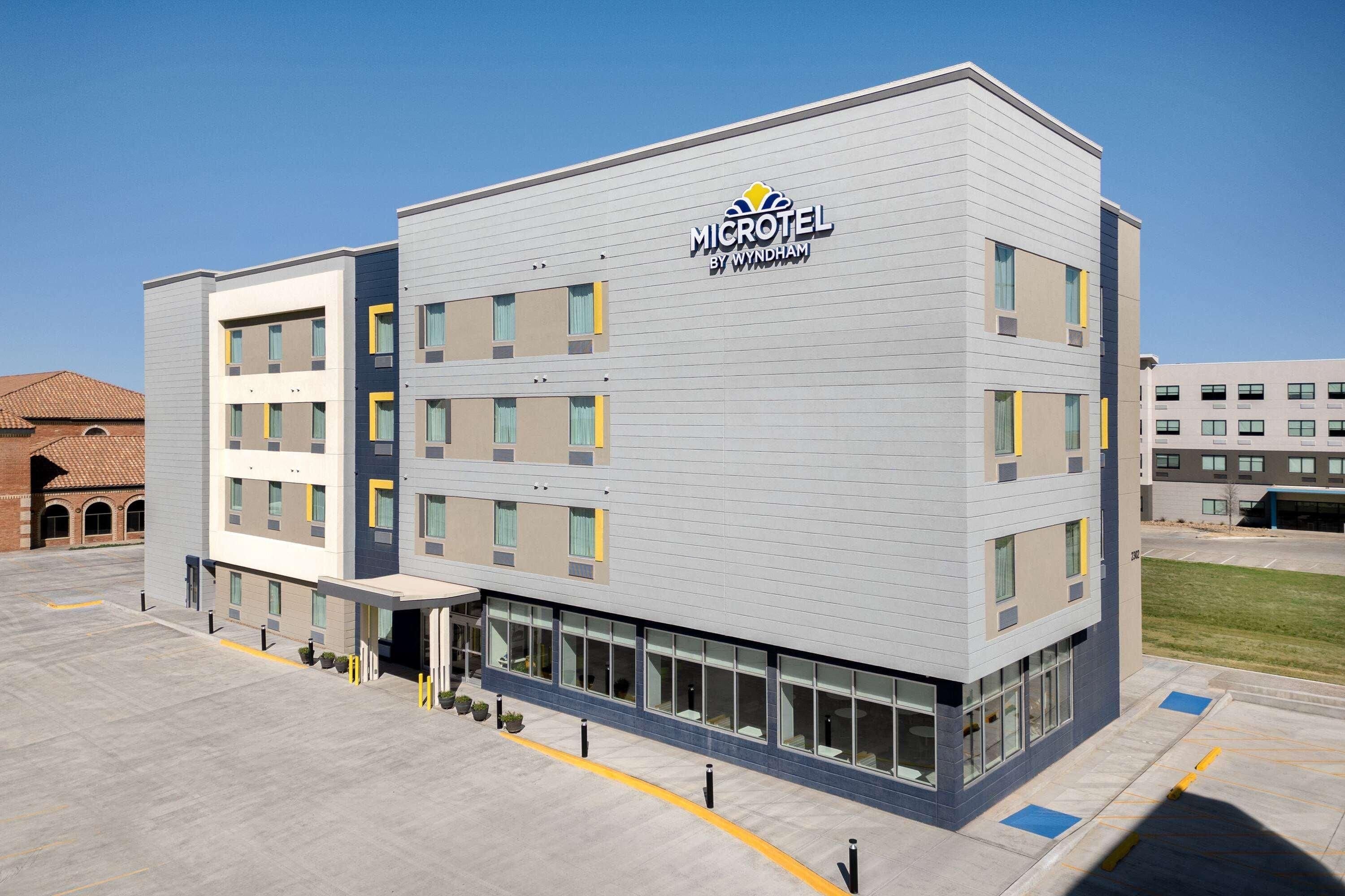 A Microtel hotel by Wyndham with a modern design, multiple floors, and a parking lot.
