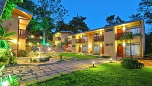 A hotel with multiple-story buildings, outdoor lighting, and a well-maintained garden area. - Monteverde Country Lodge (Monteverde)