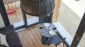 A modern room with a round table set for four, a sofa, and a large window. - Open space on two floors in detached cottage in ancient medieval courtyard (Solarolo)