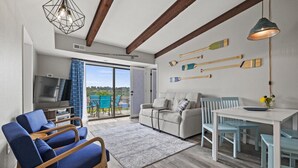 A modern living room with a sofa, chairs, a dining table, and a TV. - Pool, Pickleball, Hot Tub, Lakeview- Lakecation (Kimberling City)