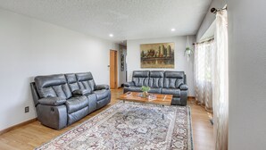Una sala de estar con dos sofás de cuero, una mesa de centro y una alfombra estampada.