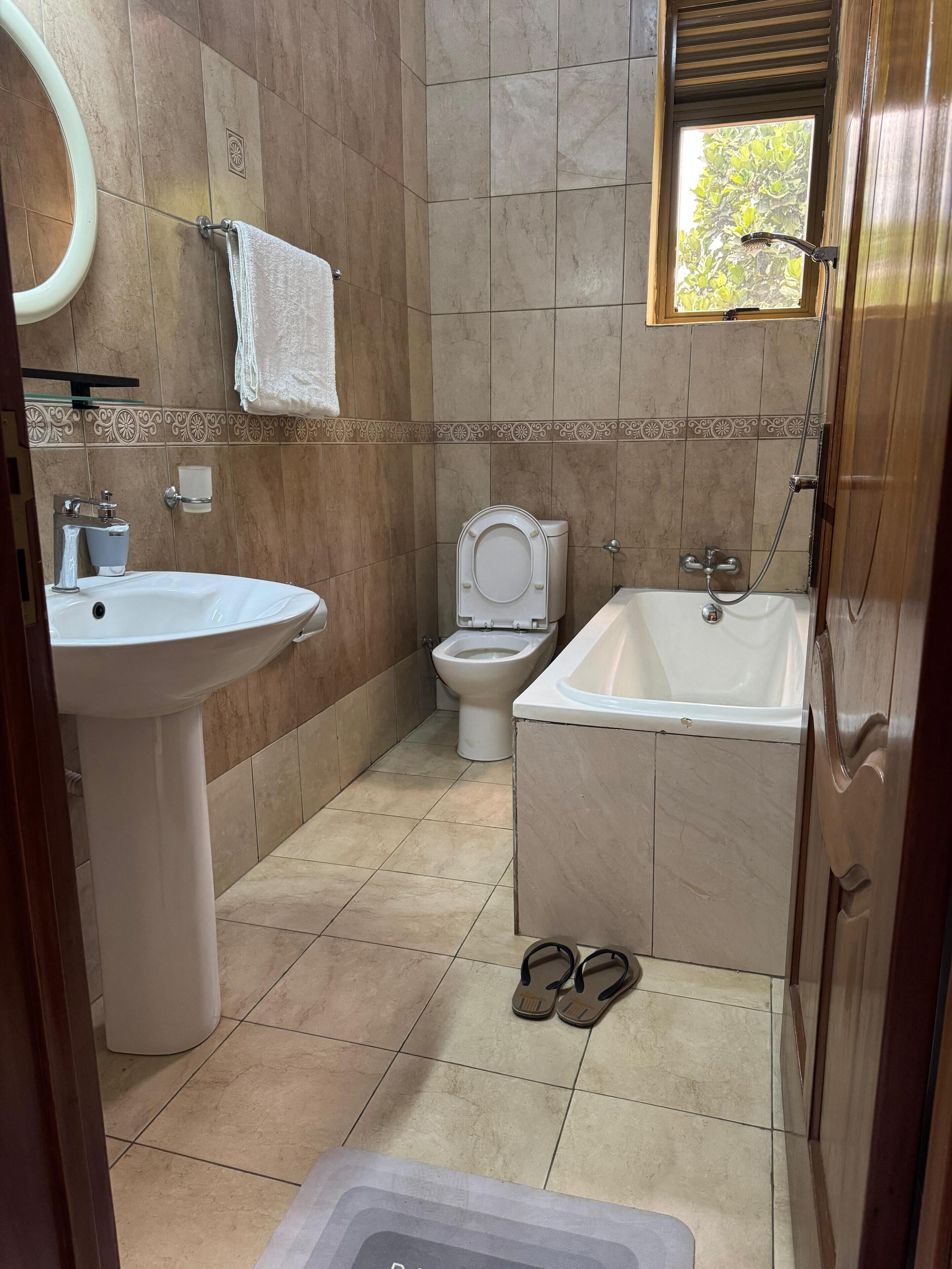 Un baño con lavamanos, inodoro y bañera.
