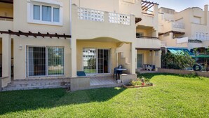 A multi-story residential building with balconies, a covered patio, and a well-maintained lawn. - Belvilla by OYO Macael Bajo 203 (Roquetas de Mar)