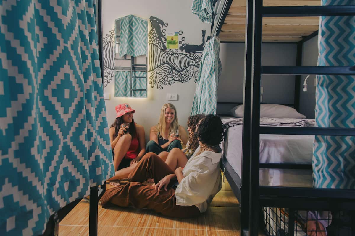 Un dormitorio con literas, cortinas estampadas y un mural en la pared.