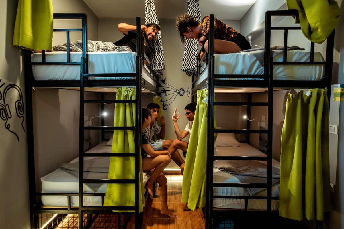 Un dormitorio con literas, una mesita y una cortina.