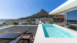 A rooftop pool with a view of a mountain and the sea. - Aquatic Penthouse - Coastal Luxury & Rooftop Views (Cape Town)