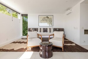 Una sala de estar moderna con un juego de sofá, una mesa de centro y un ventanal grande.