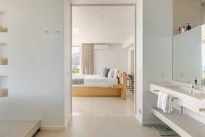 A modern bedroom with a bed, a bedside table, and a large window.