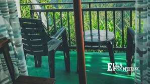 Un balcon offrant une vue sur un paysage montagneux, avec une table et des chaises.