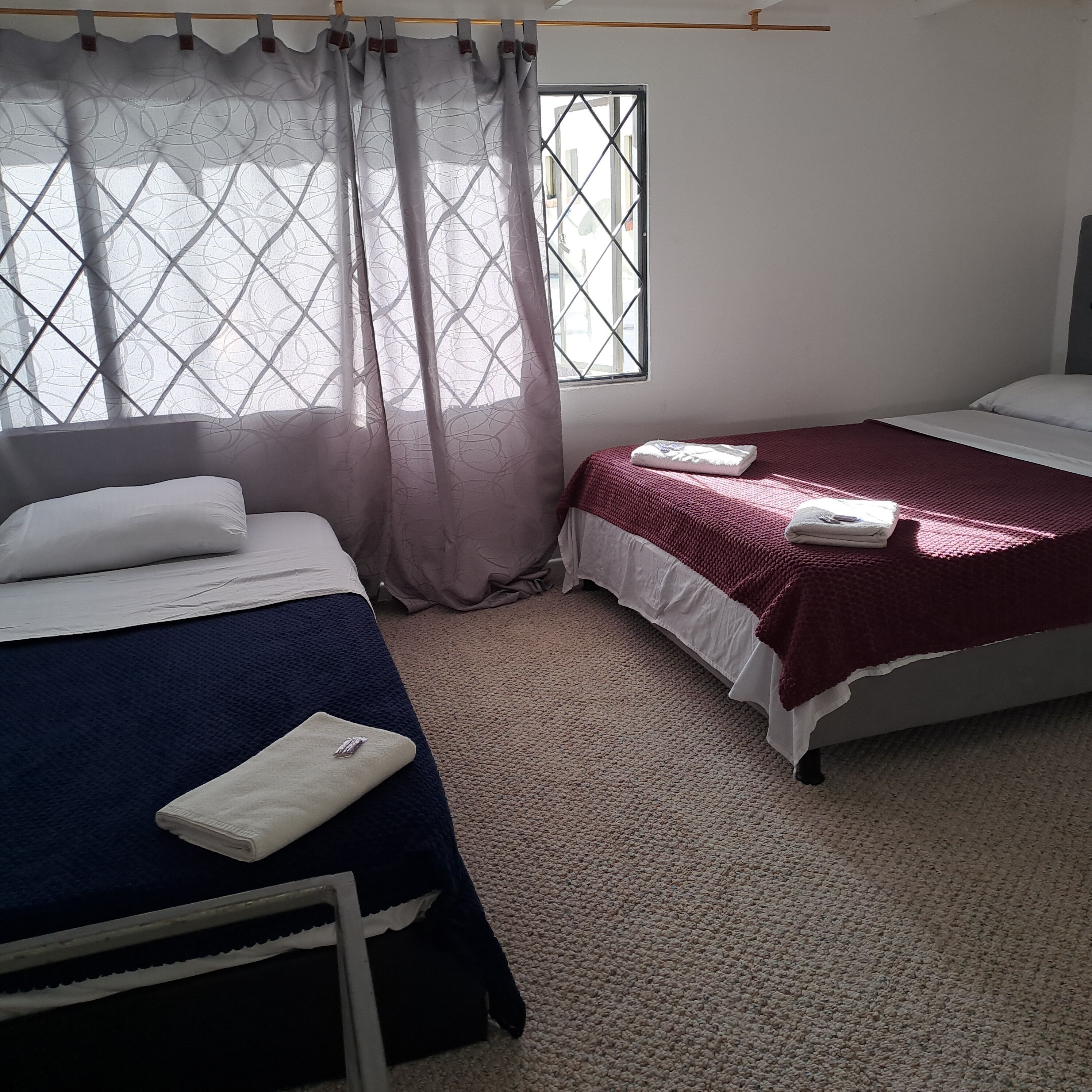 Un dormitorio con dos camas, una ventana con vistas y una cortina.