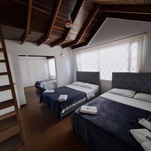 A hotel room with two beds, a wardrobe, and a window with blinds. - Fortaleza Diosa Chia (Chia)