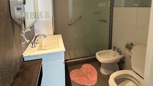 Ein modernes Badezimmer mit Dusche, Toilette, Bidet und Waschbecken.