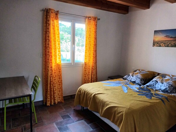 A bedroom with a bed, a chair, curtains, a window, and a painting on the wall. - AUBENAS-VALS LES BAINS-VALLON PONT D'ARC BEAUTIFUL NEW AIR-CONDITIONED VILLA (Vesseaux)