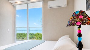 Ein Hotelzimmer mit Bett, Meerblick und Klimaanlage.