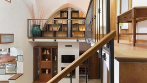Un loft spazioso con un soppalco, angolo cottura e una scala.