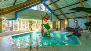 En inomhuspool med en vattenrutschkana, en livräddarstation och en väggmålning som föreställer en sjöjungfru.