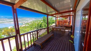 A wooden deck with a bench, a table, and chairs, overlooking a scenic view of a lake and mountains. - Adria Family Zone B 6+1 (Klenovica)