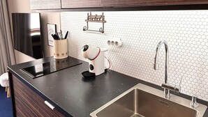 Une cuisine moderne avec des meubles de couleur bois foncé, un évier en acier inoxydable et un plan de travail noir.