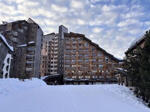 A multi-story hotel with a wooden facade, balconies, and a ski slope in the background. - 10m from ski slopes, 3rd floor, tv, 25m², Avoriaz (Avoriaz)