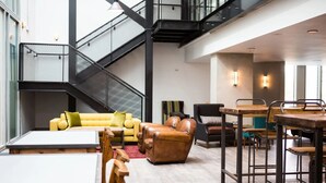 A spacious, modern interior with a staircase, seating area, and dining space. - Chapter Kings Cross - Campus Accommodation (London)