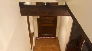 Eine Holztreppe mit Handlauf führt zu einer Tür oben.